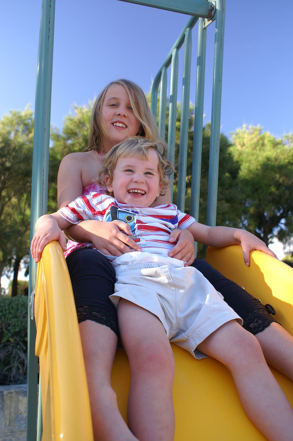 family photography brother and sister together on slide in park