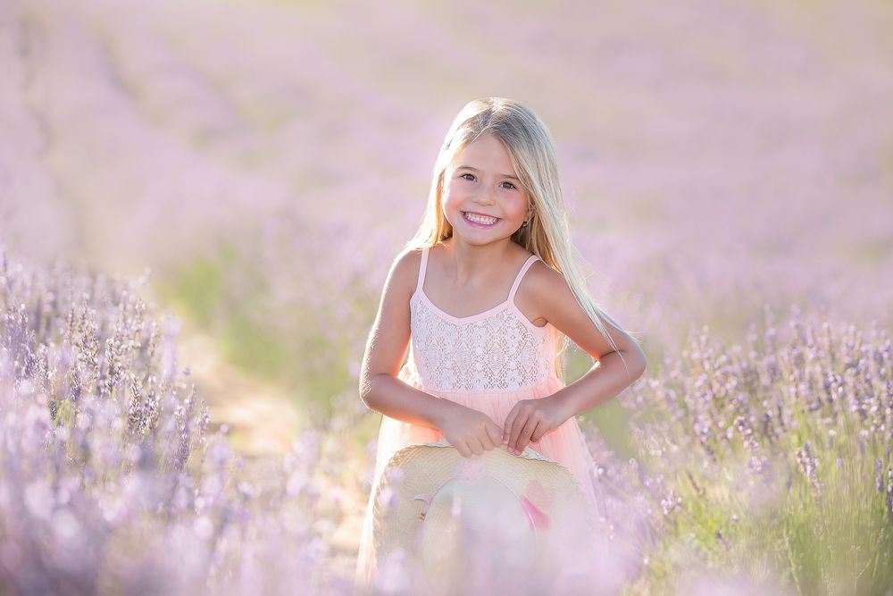 family photography girl in summer dress standing in lavender field