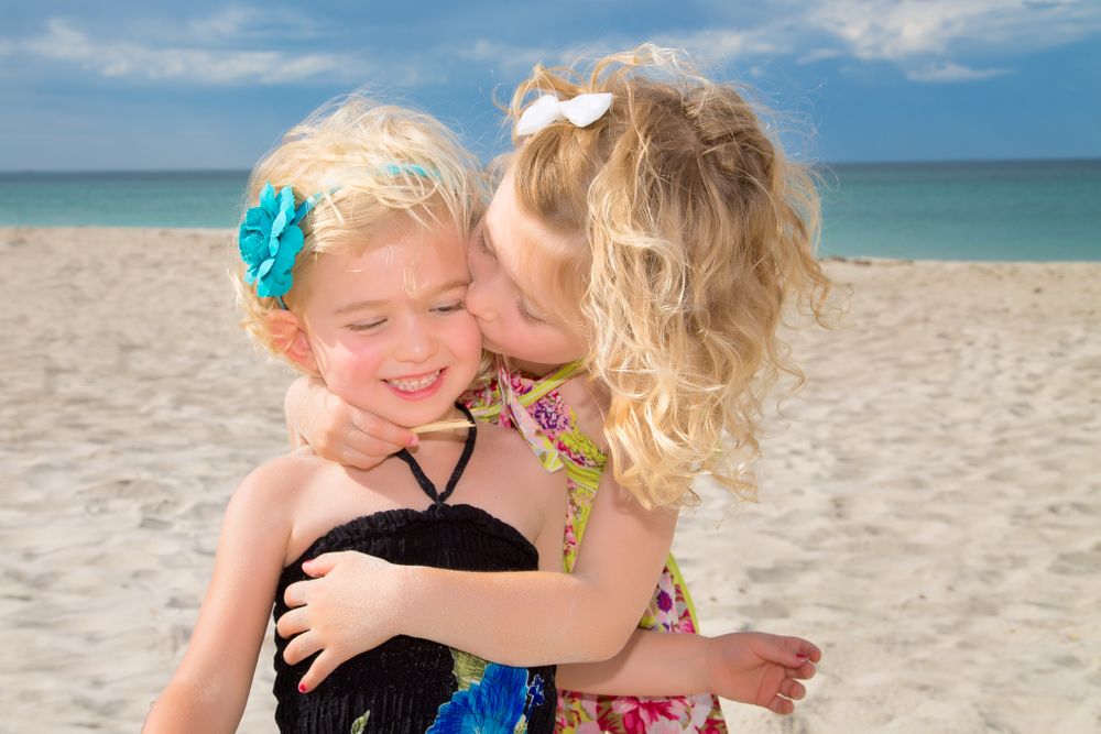family photography two girls cuddling on beach