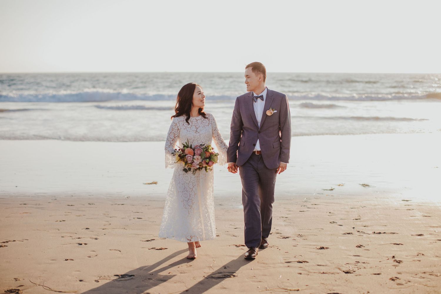 bride & groom walking on beach