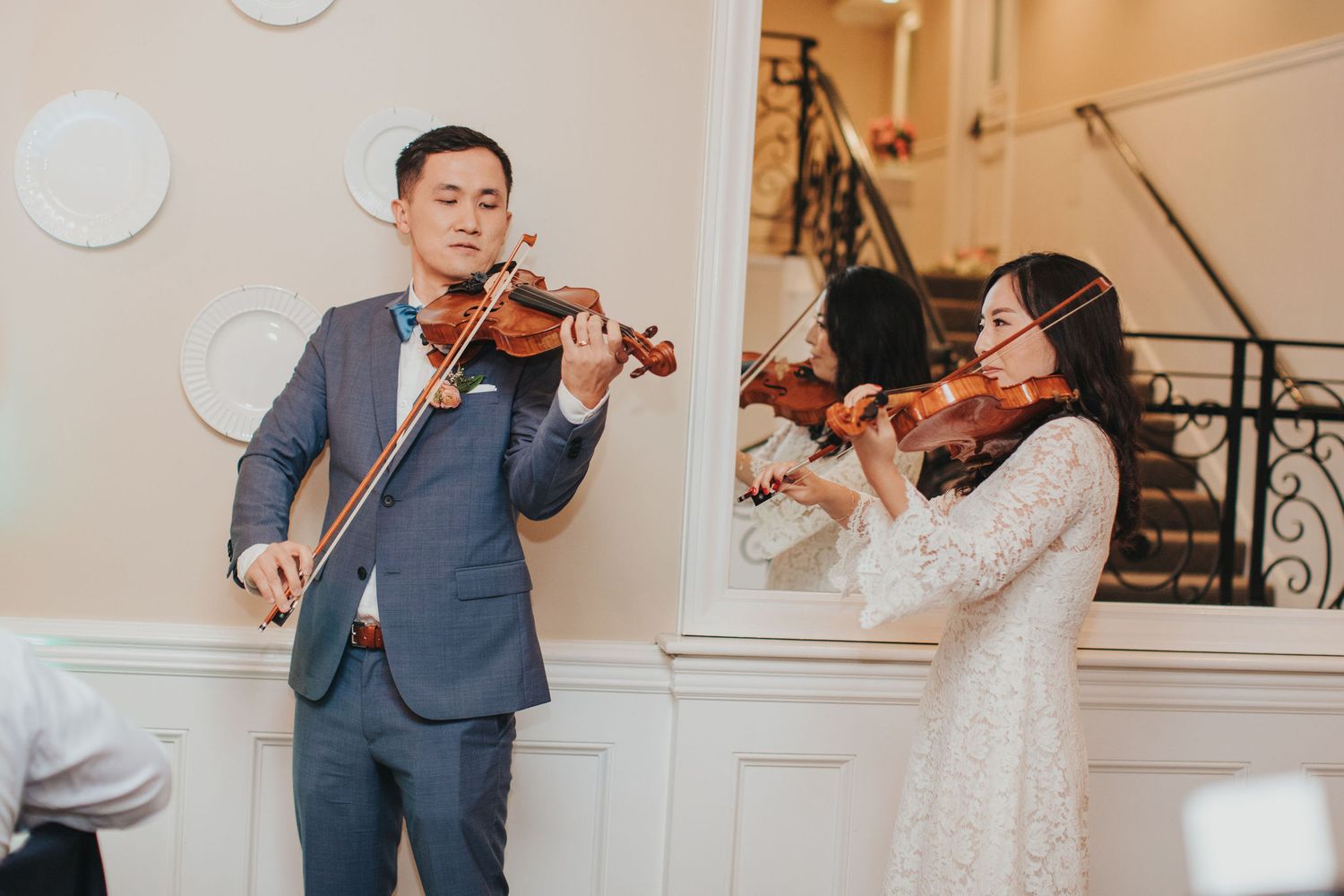 bride & groom play violins for guests at verandas manhattan beach