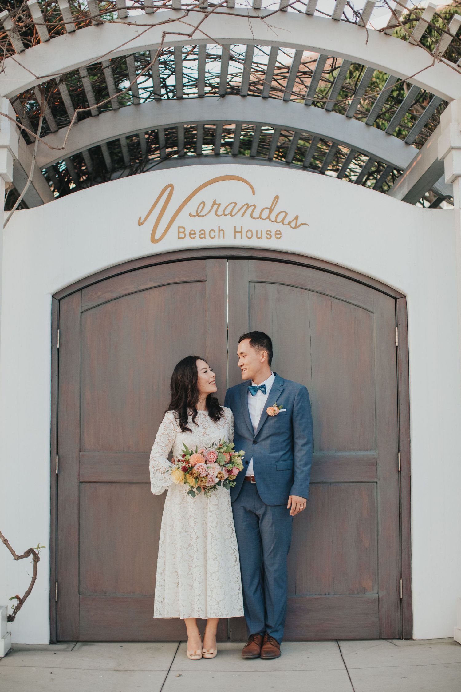 bride & groom looking at each other under arch