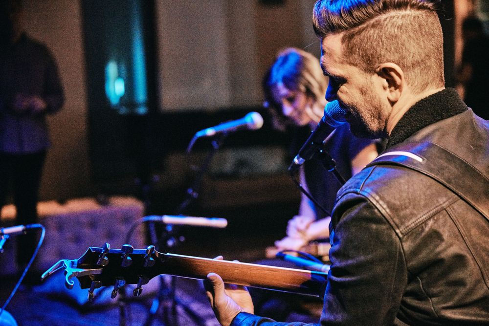Andy Grammer preforming a song, playing his guitar in an intimate setting at Only In Nashville. Photo by Joel Alexander