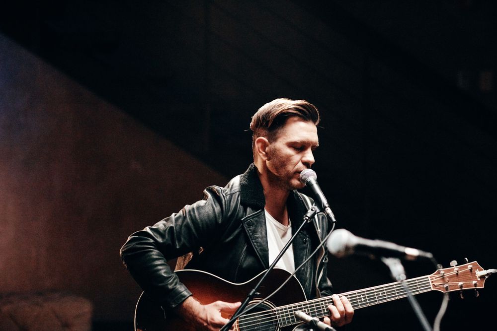 Andy Grammer strumming his distressed sunburst acoustic guitar at Only In Nashville. Photo: Joel Alexander.