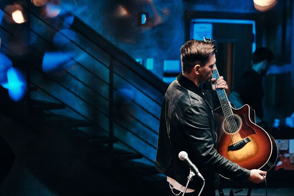 Andy Grammer unplugging his distressed sunburst acoustic guitar at Only In Nashville. Photo by Joel Alexander.