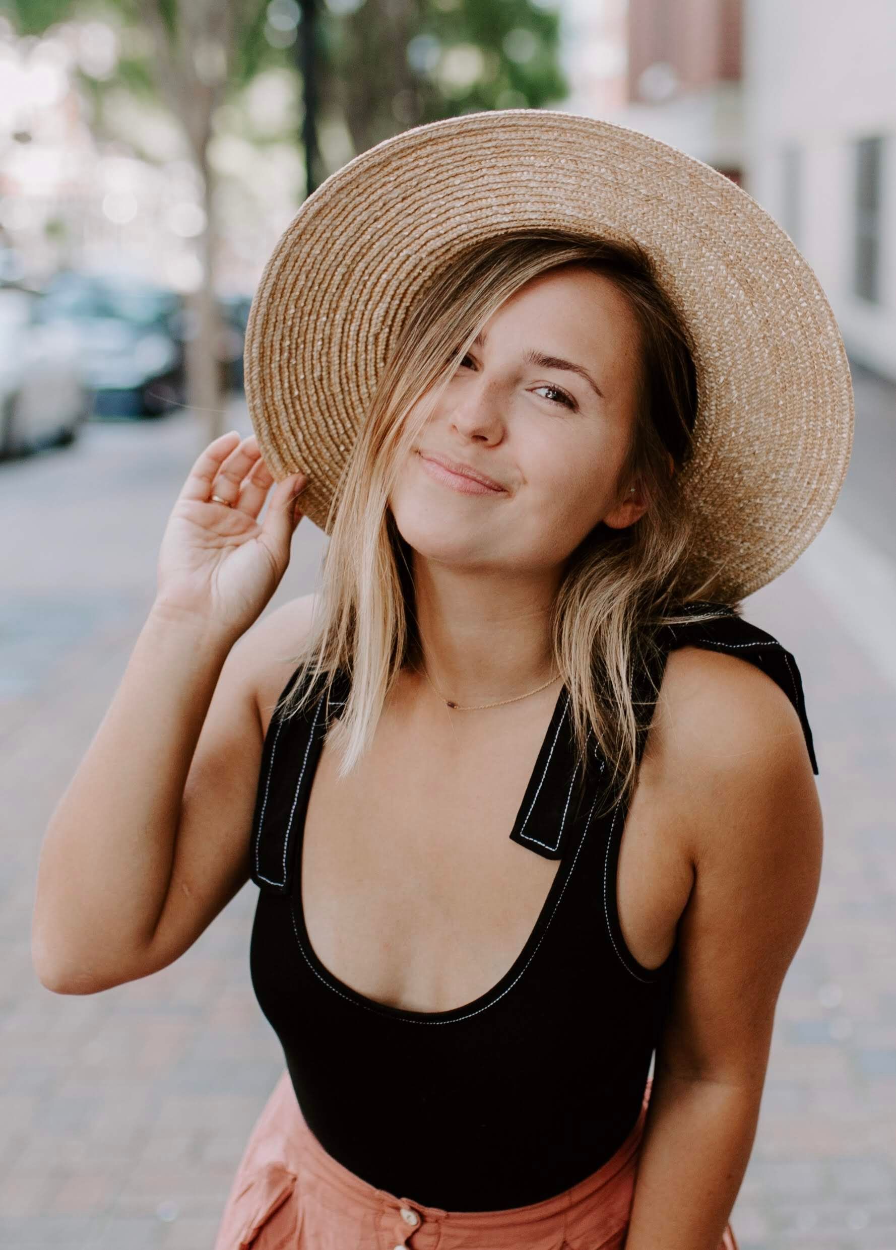 girl smiling wearing a straw hat
