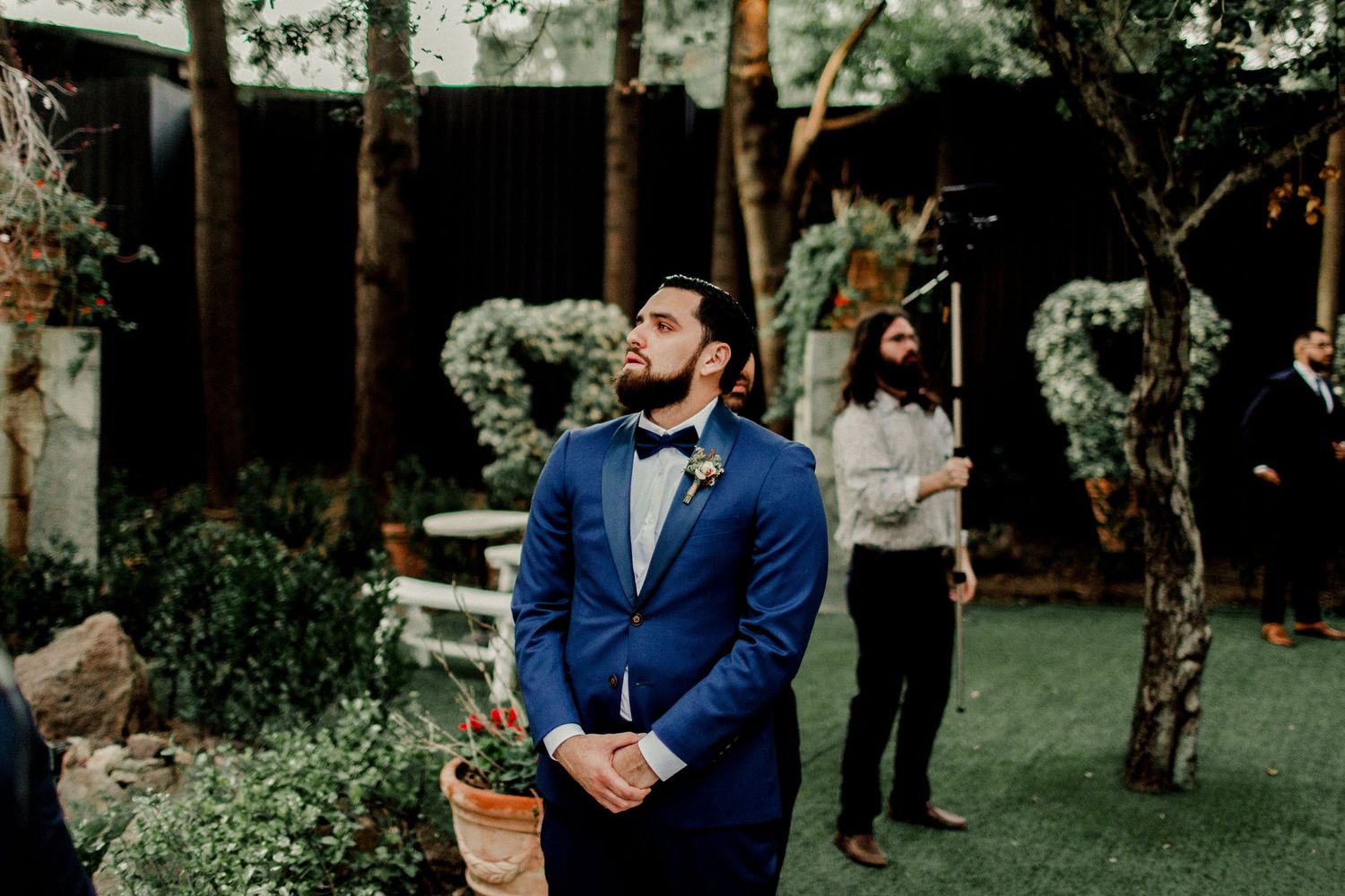 groom holding back tears while preparing for bride to walk down aisle