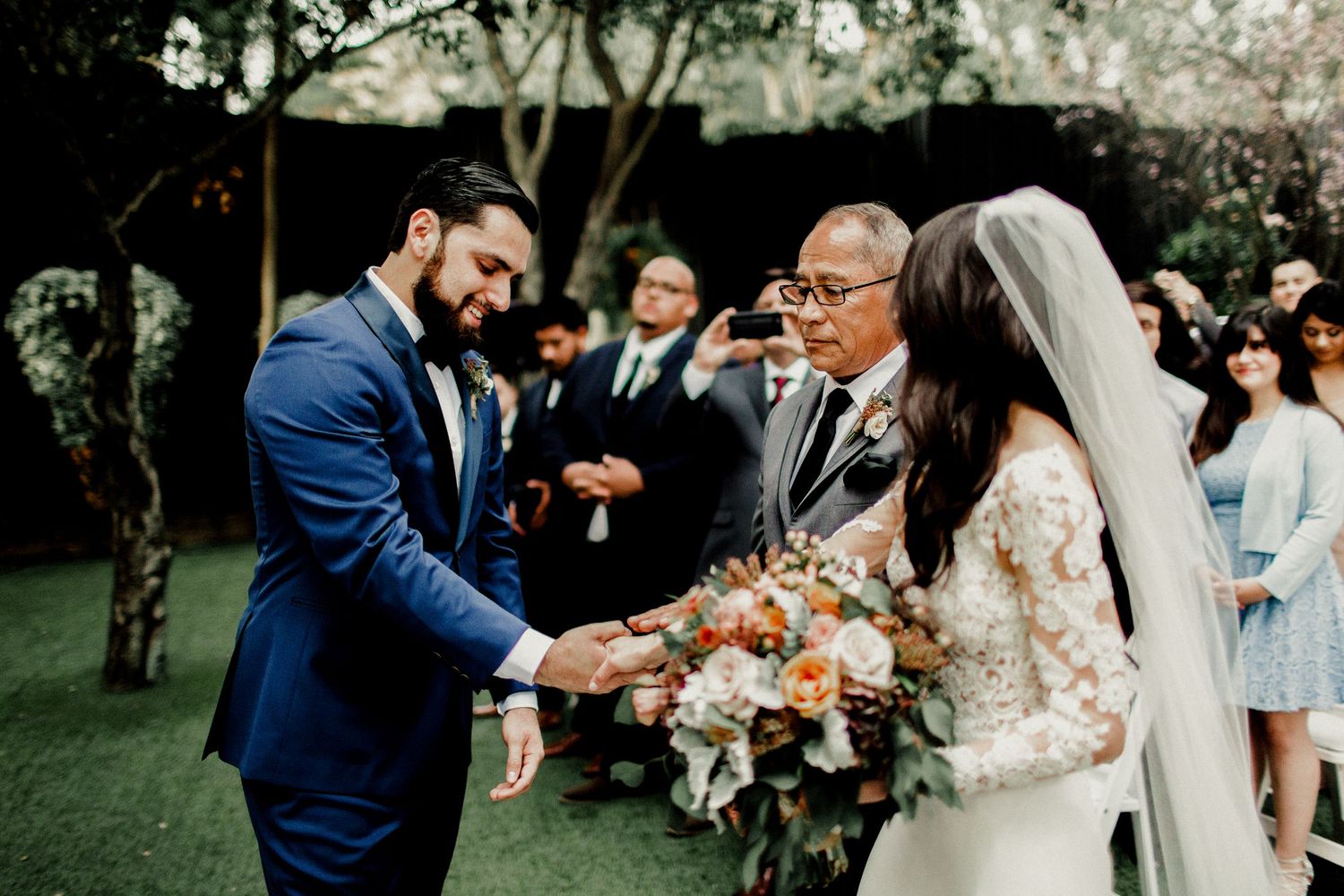 father passing bride to groom during wedding ceremony