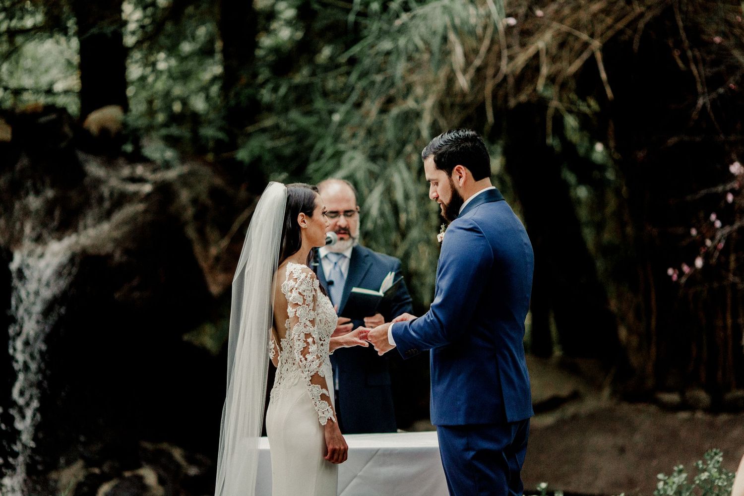 groom putting on ring for bride