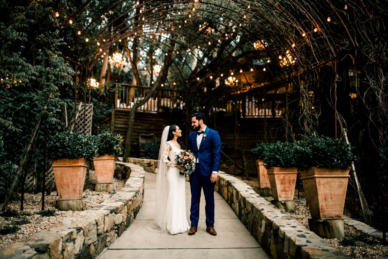 bride and groom standing in front of arch at calamigos ranch birchwood room malibu