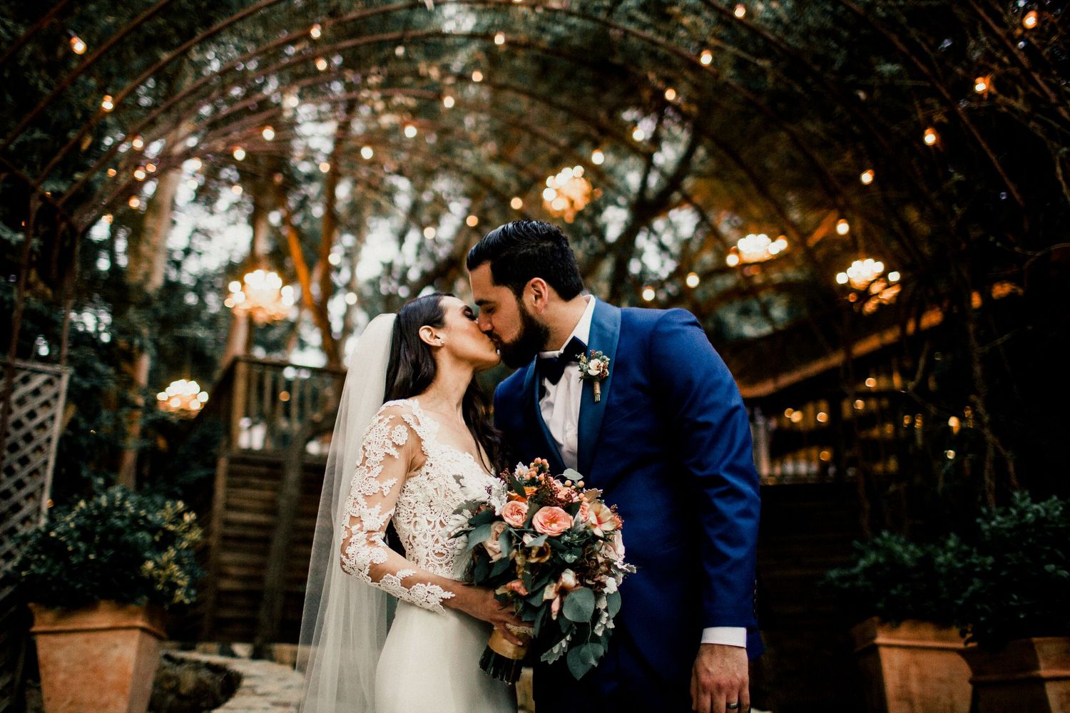 bride and groom kissing in front of calamigos ranch arch malibu