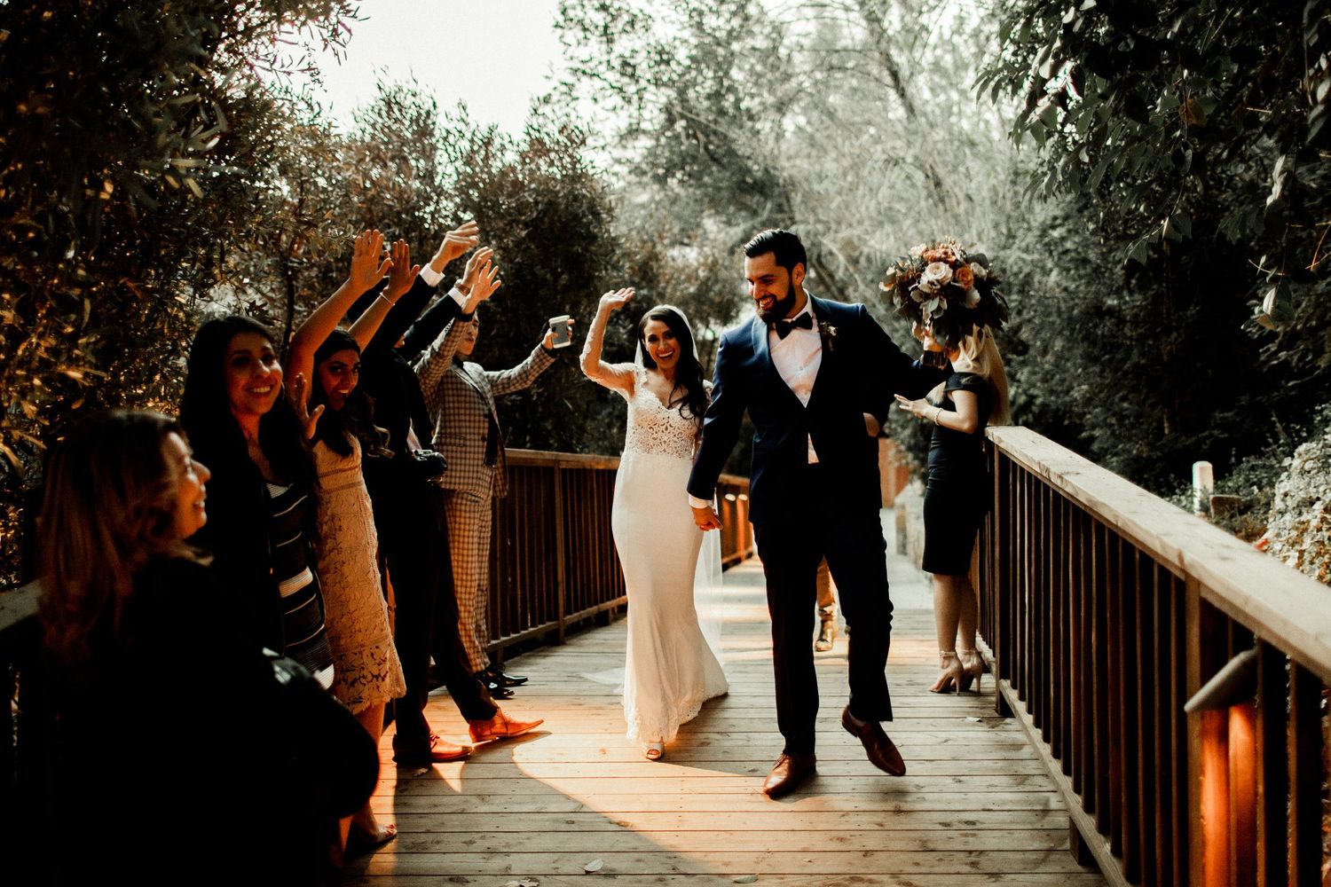 bride and groom returning with friends cheering on