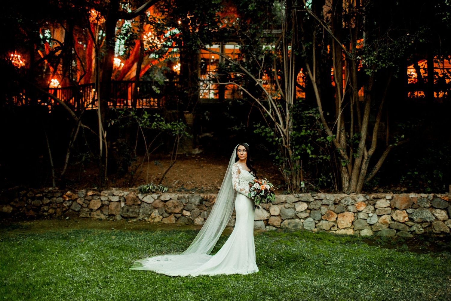 bride in wedding dress looking away with calamigos ranch malibu reception in background