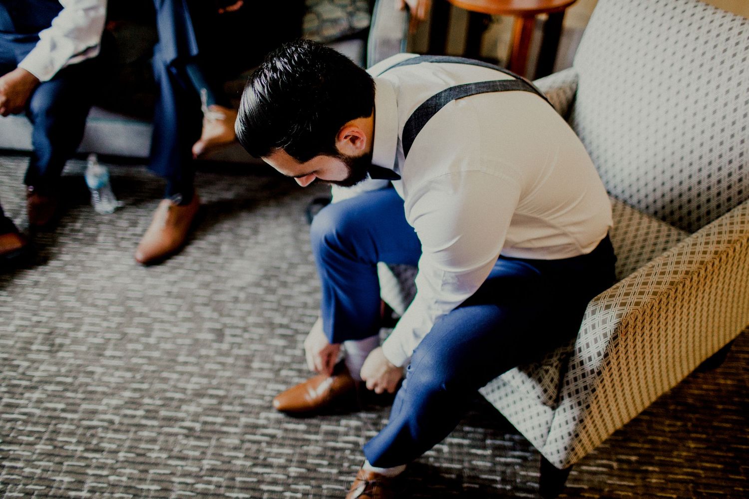 groom putting on dress shoes