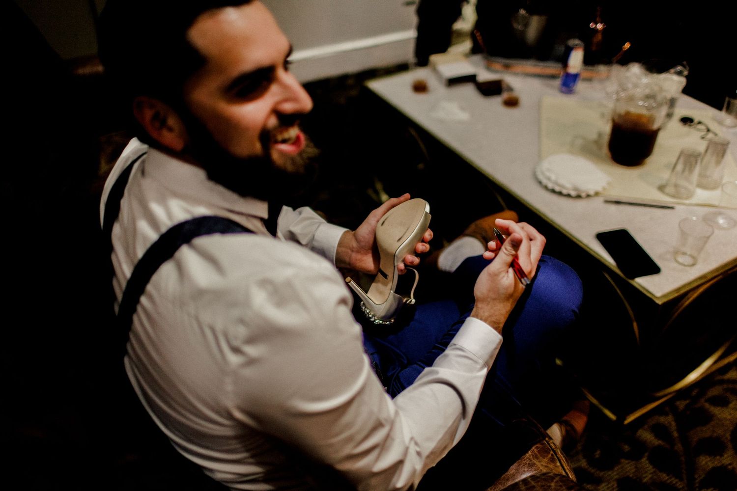 groom writing a special message for bride on shoe