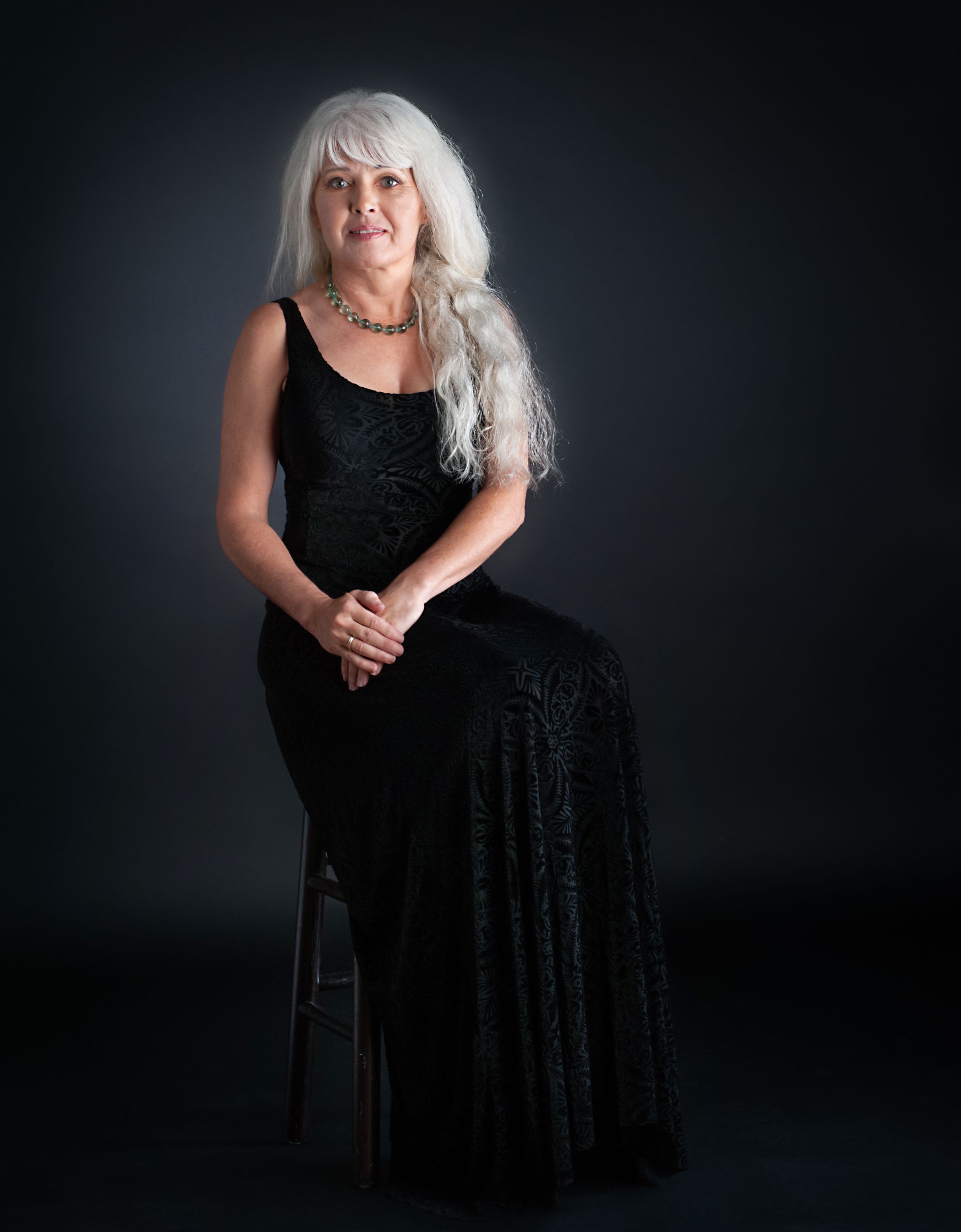 silver haired beauty sits for portrait