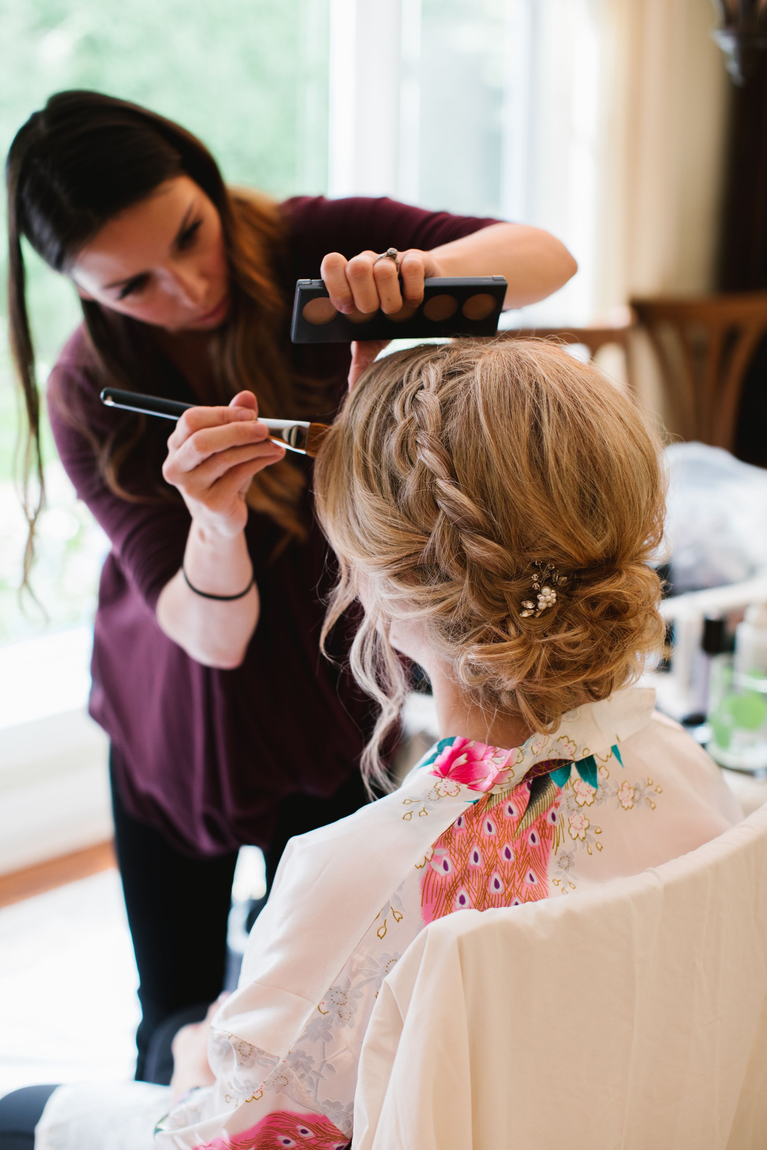 bride having her makeup done, back of her hair and makeup artist