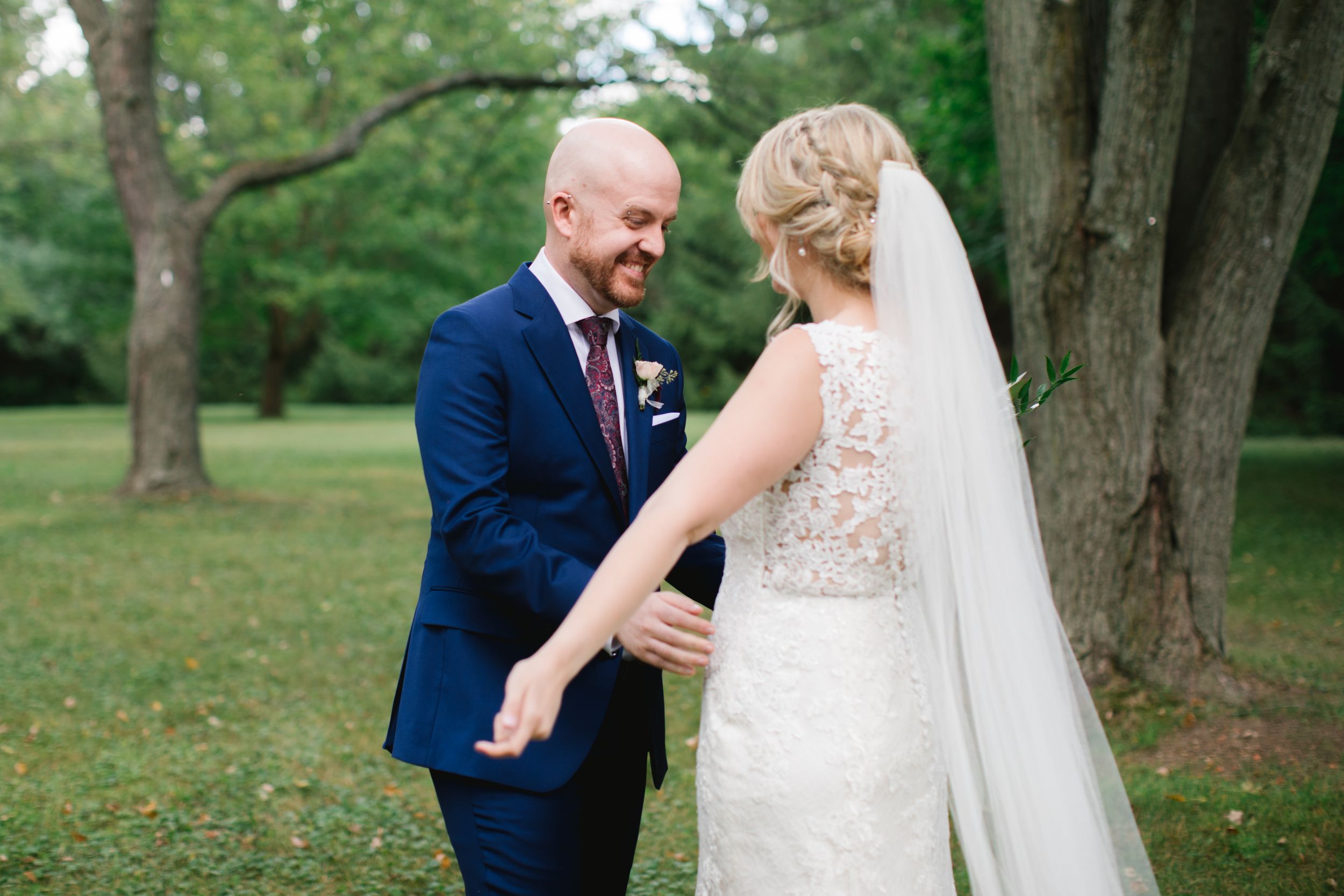 groom smiling and going in for a hug with the bride