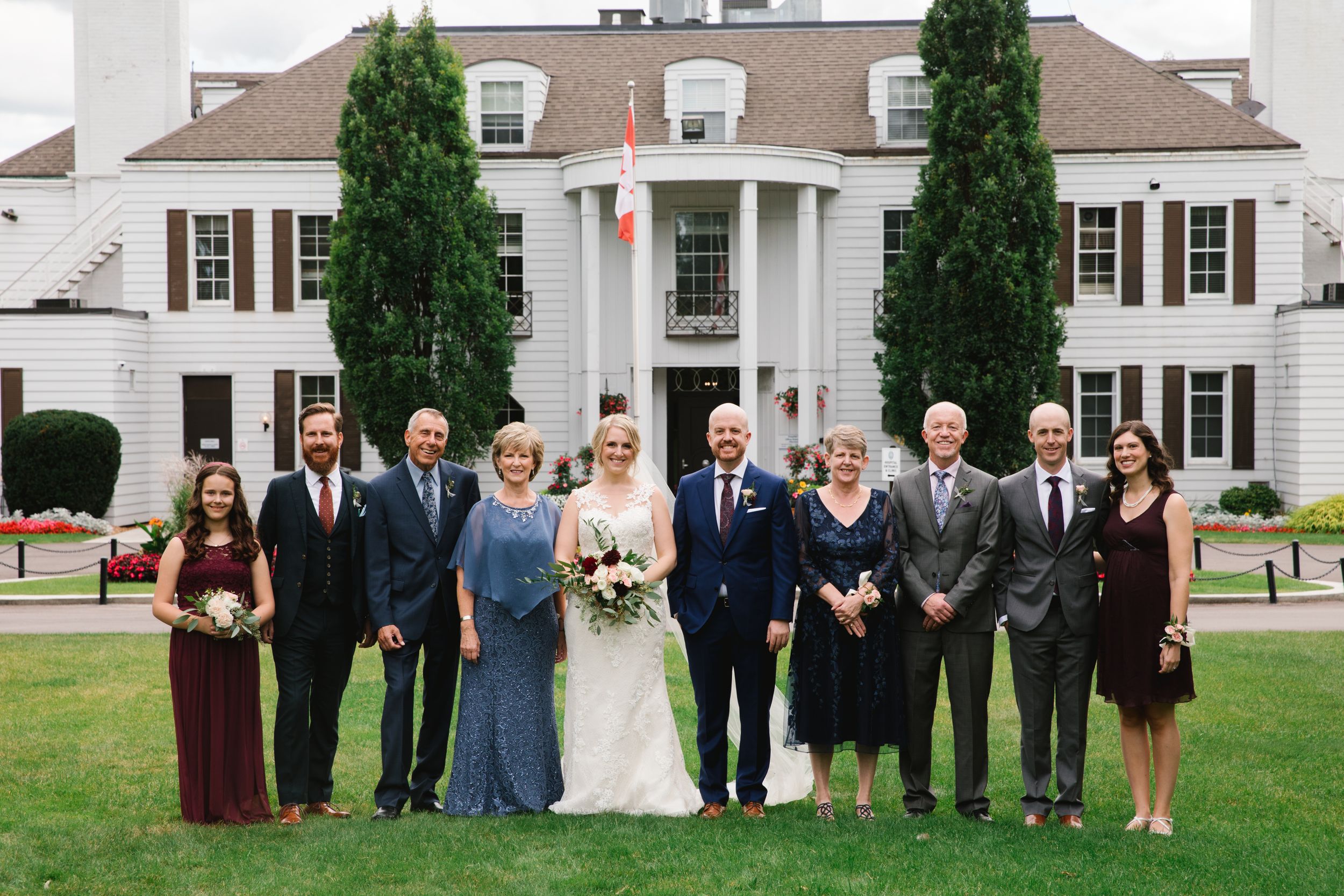 bride and groom with family in front of white building shouldice hospital wedding