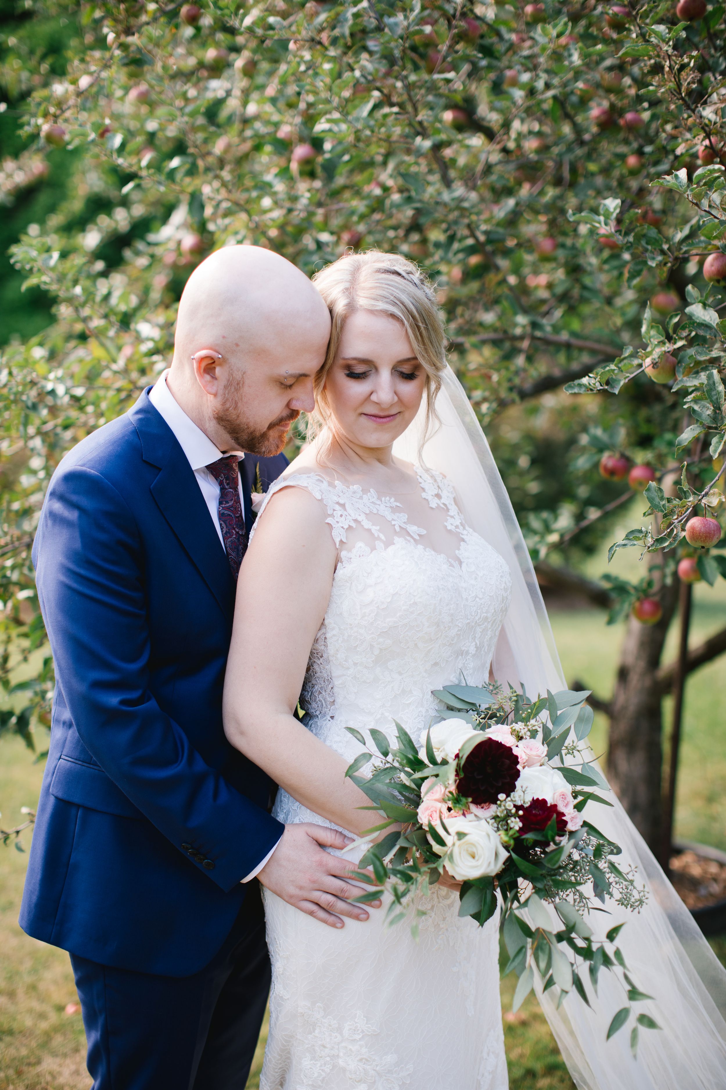 groom in blue suit hugging bride from behind