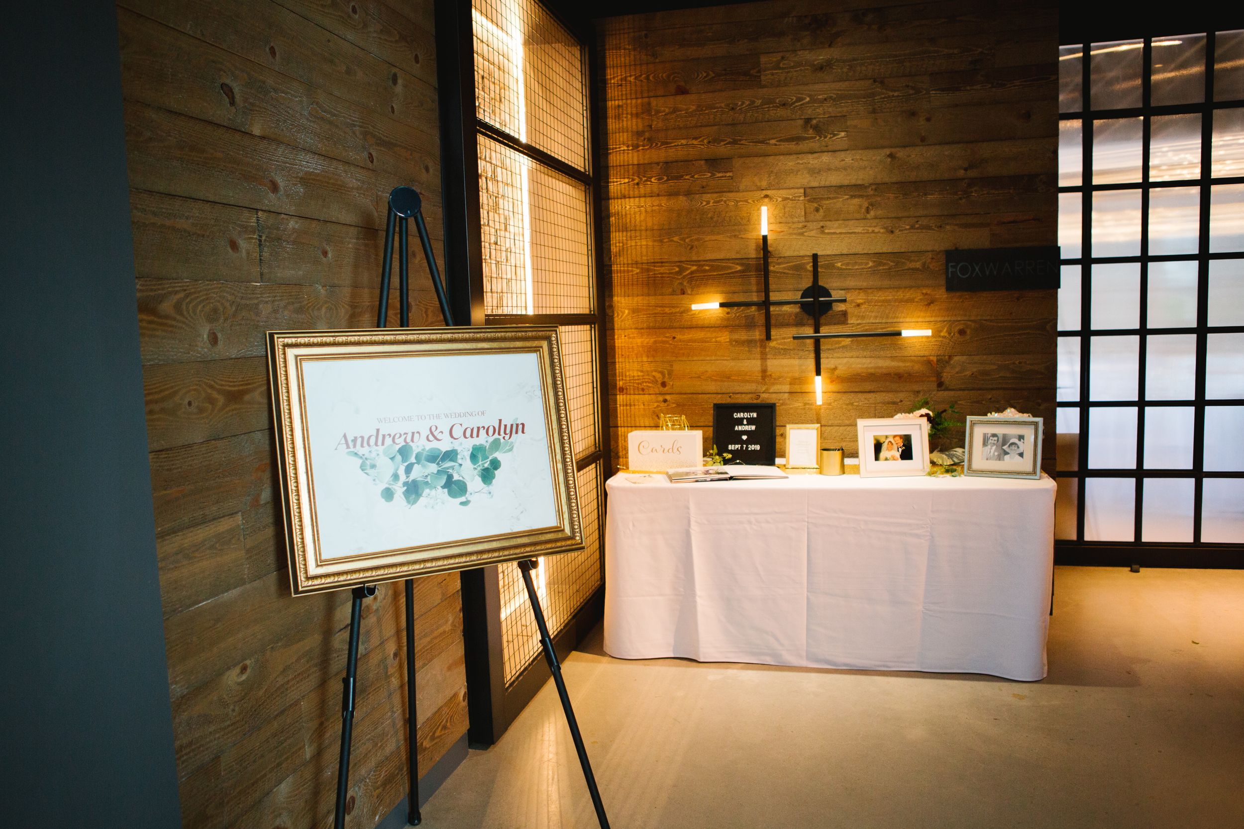 reception entrance set up, gold sign and signing table in wooden industrial room village loft events
