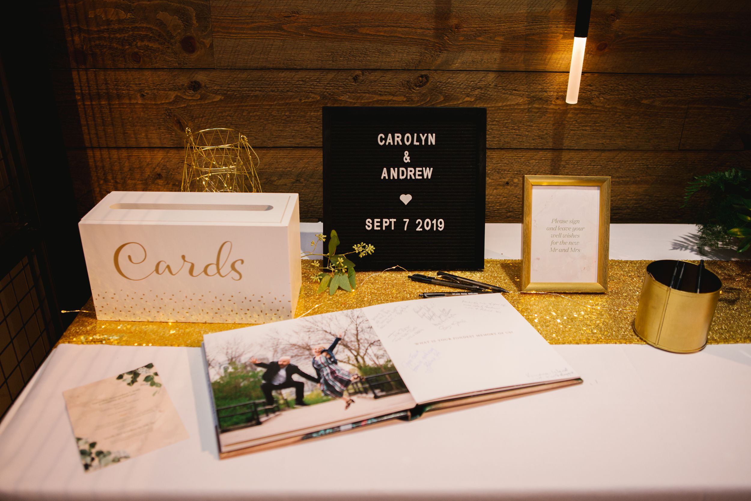 cards table with black felt sign and guest signing book with gold accents wedding