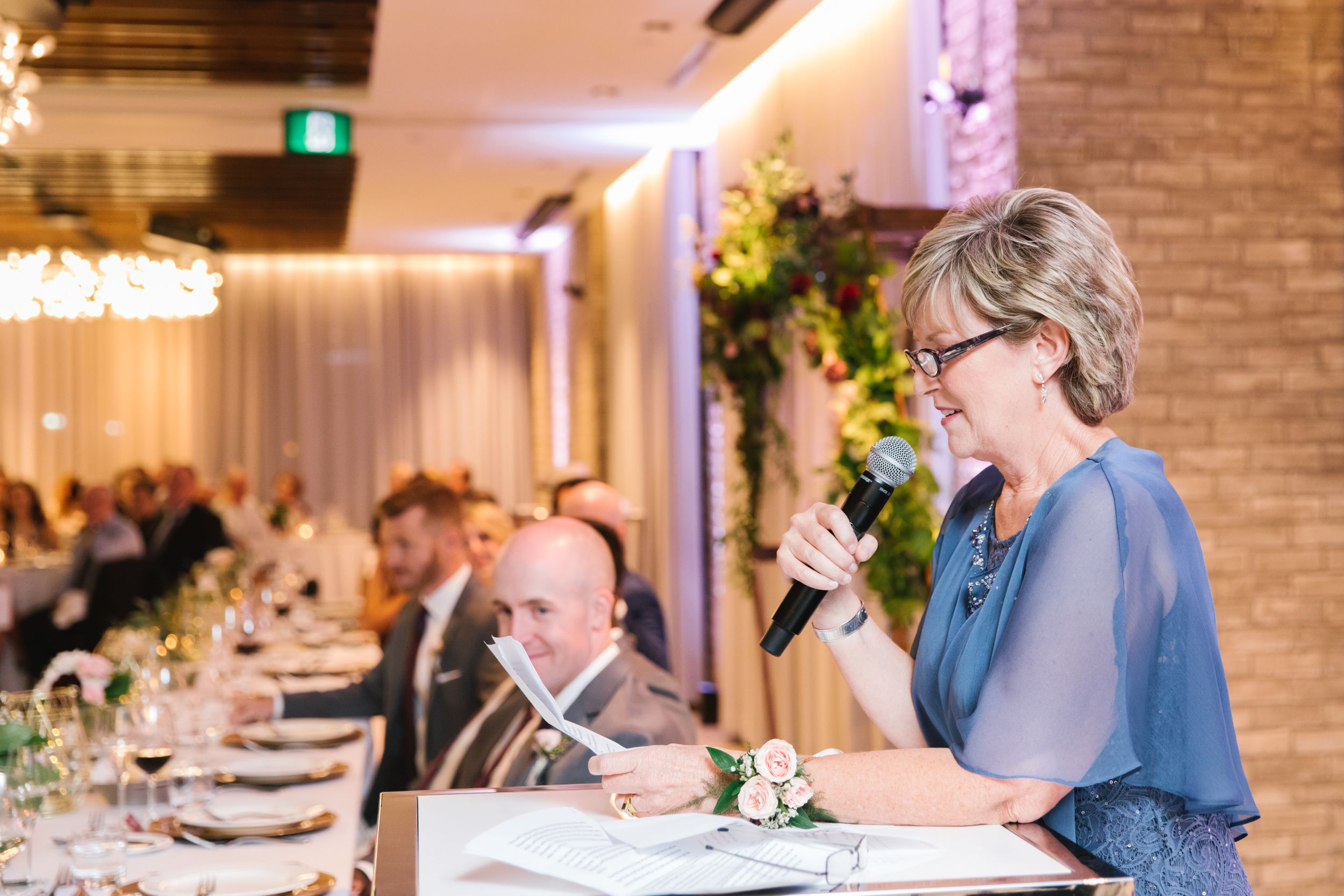 mother of bride making a speech with head table behind her