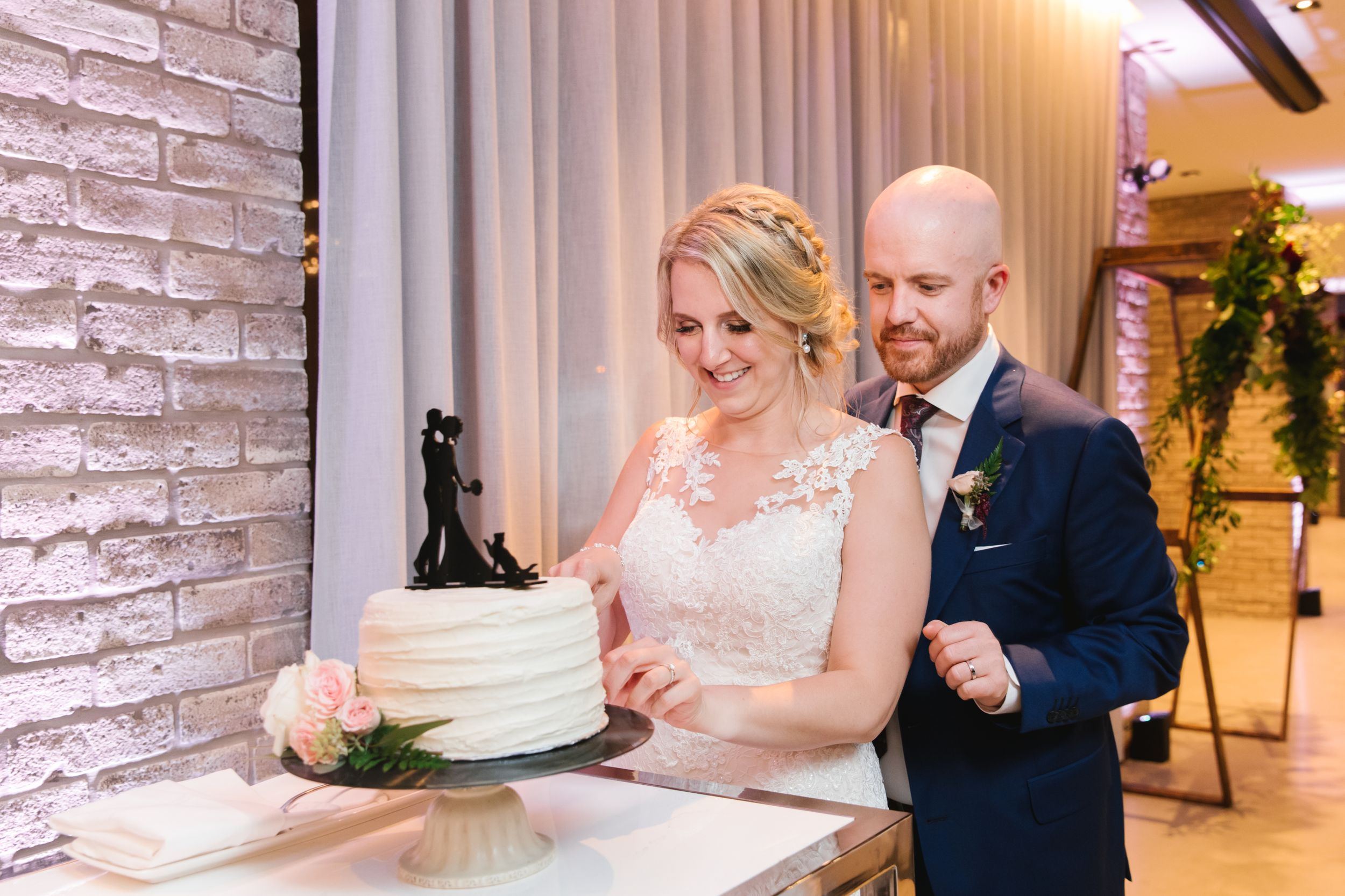 bride and groom cutting small white simple cake