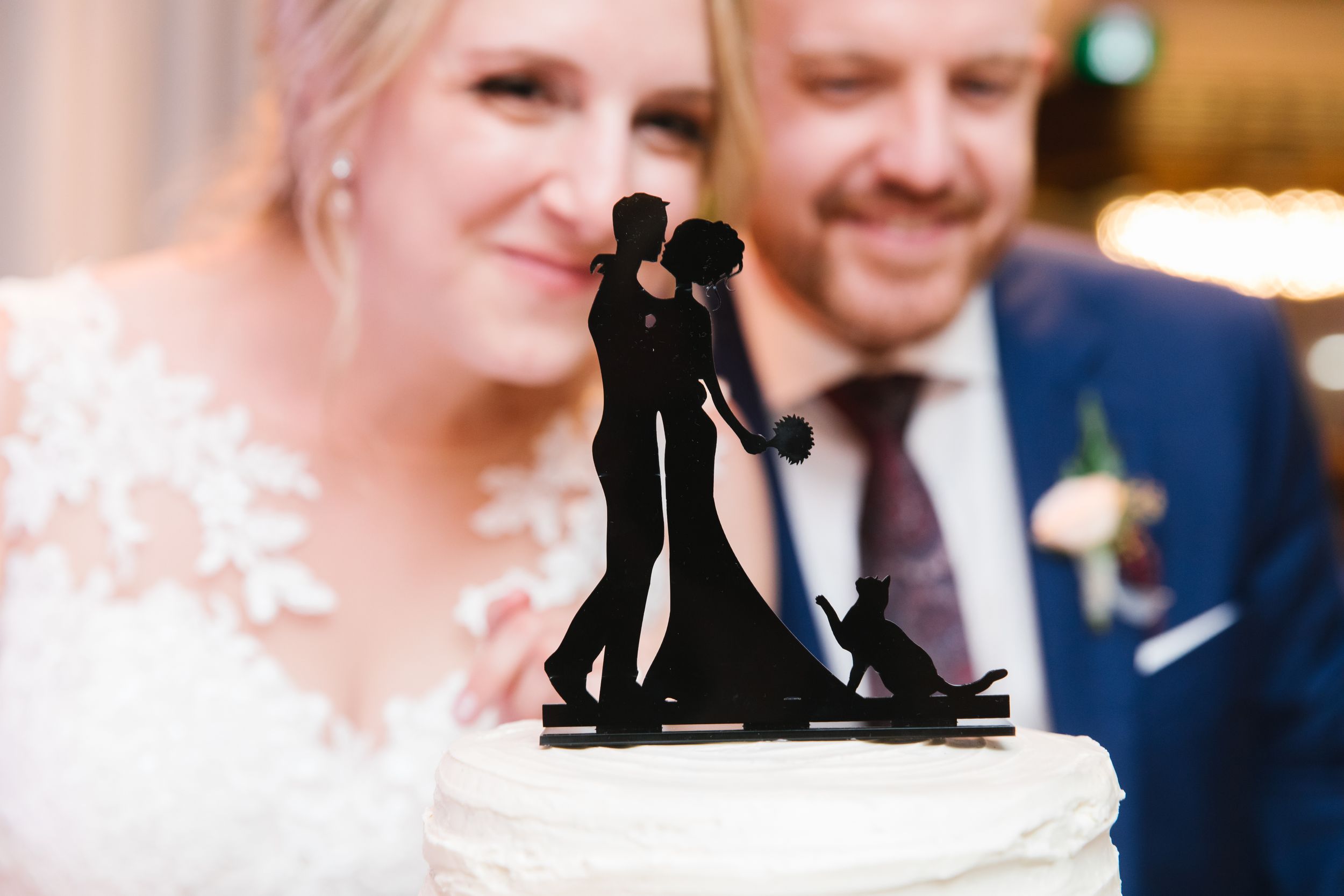 black cut out cake topper with bride and groom in the background