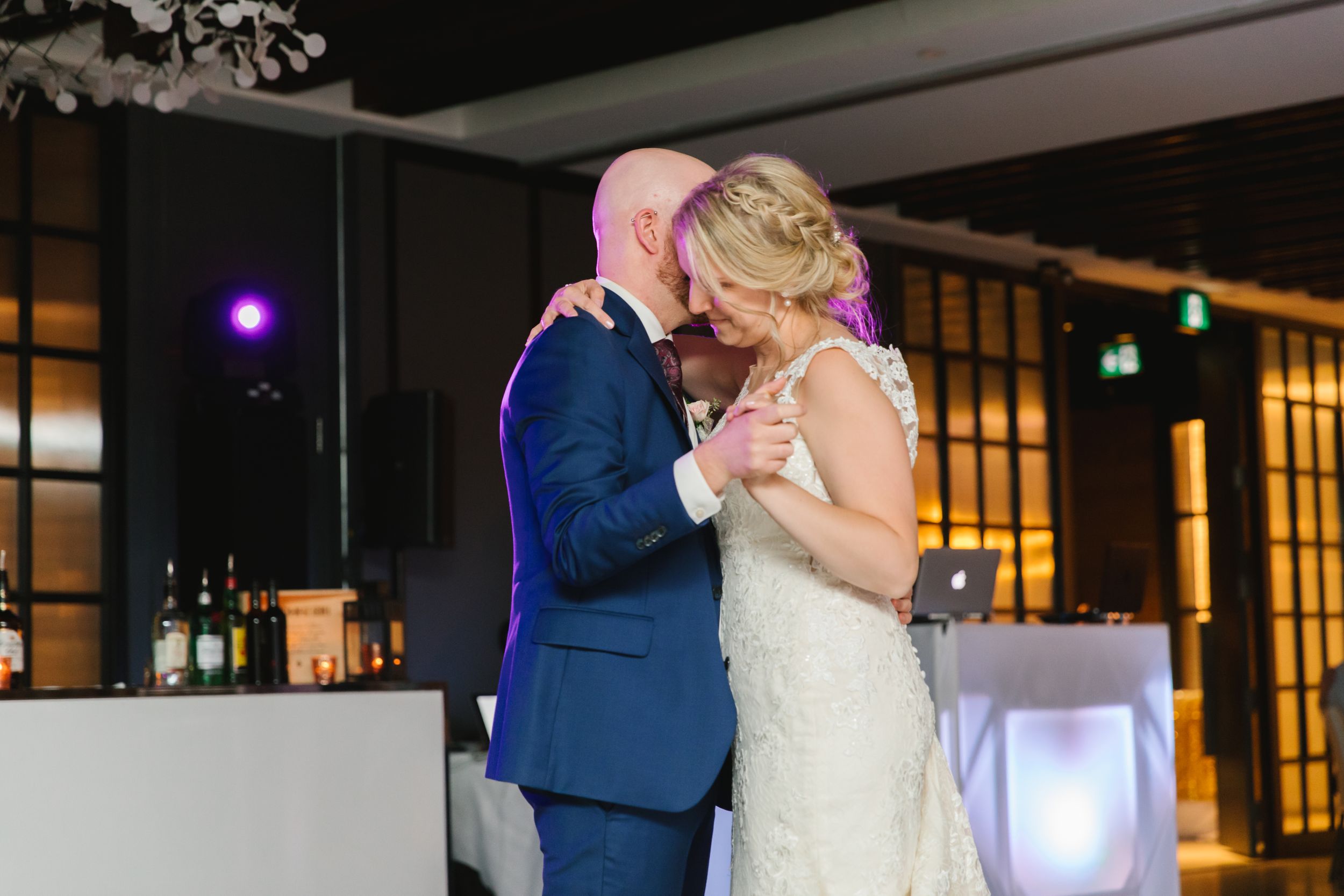 bride and groom first dance hugging close in industrial loft event space