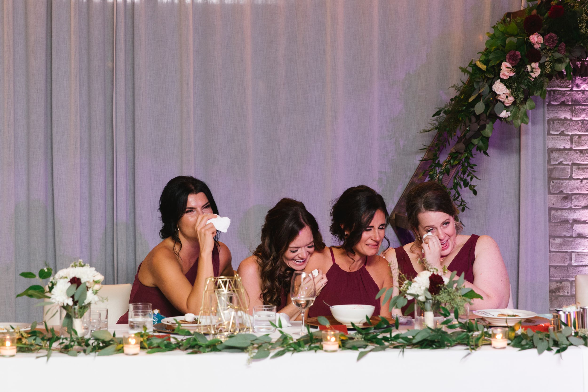 four bridesmaids crying and holding tissues during first dance