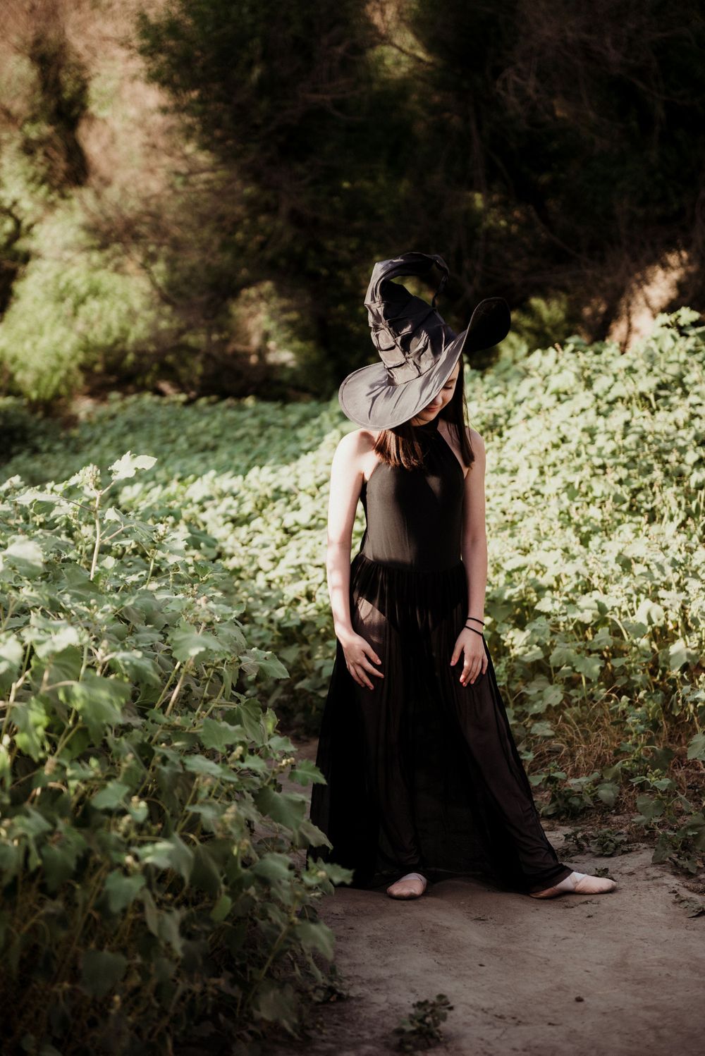 Girl posing in a witch costume with her hat covering her face for a Halloween photoshoot in Three Rivers CA