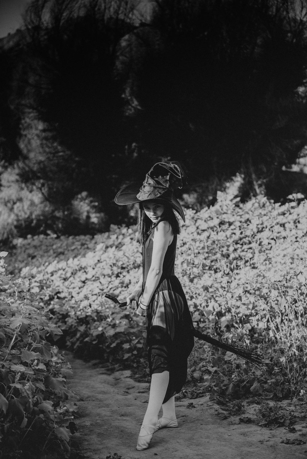 Girl posing in a witch costume on a broom for a Halloween photoshoot in Three Rivers CA