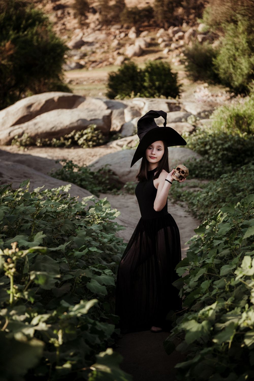 Girl posing in a witch costume with a skull for a Halloween photoshoot in Three Rivers CA