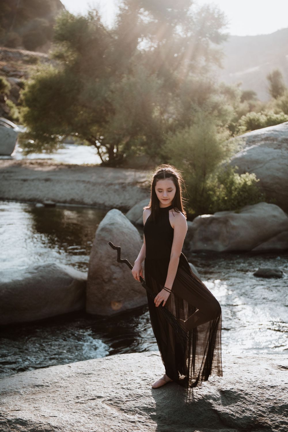 Girl posing on a broom in front of the river; Halloween photoshoot in Three Rivers, California