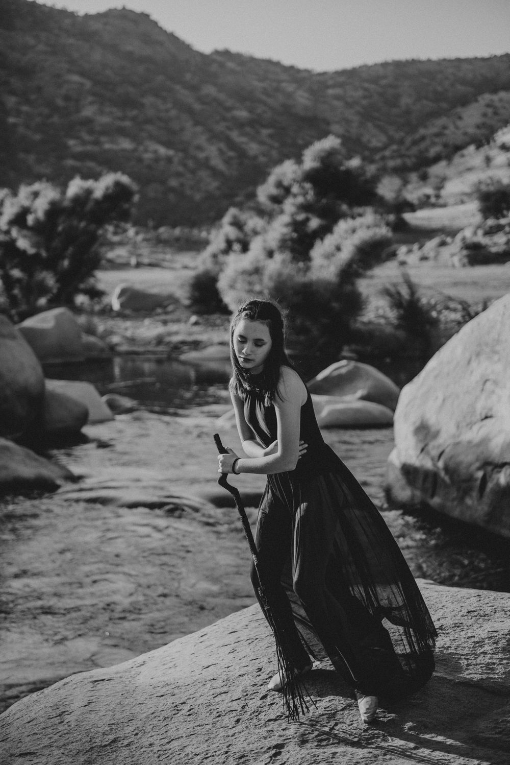 Girl posing with a broom in front of the river; Halloween photoshoot in Three Rivers, California