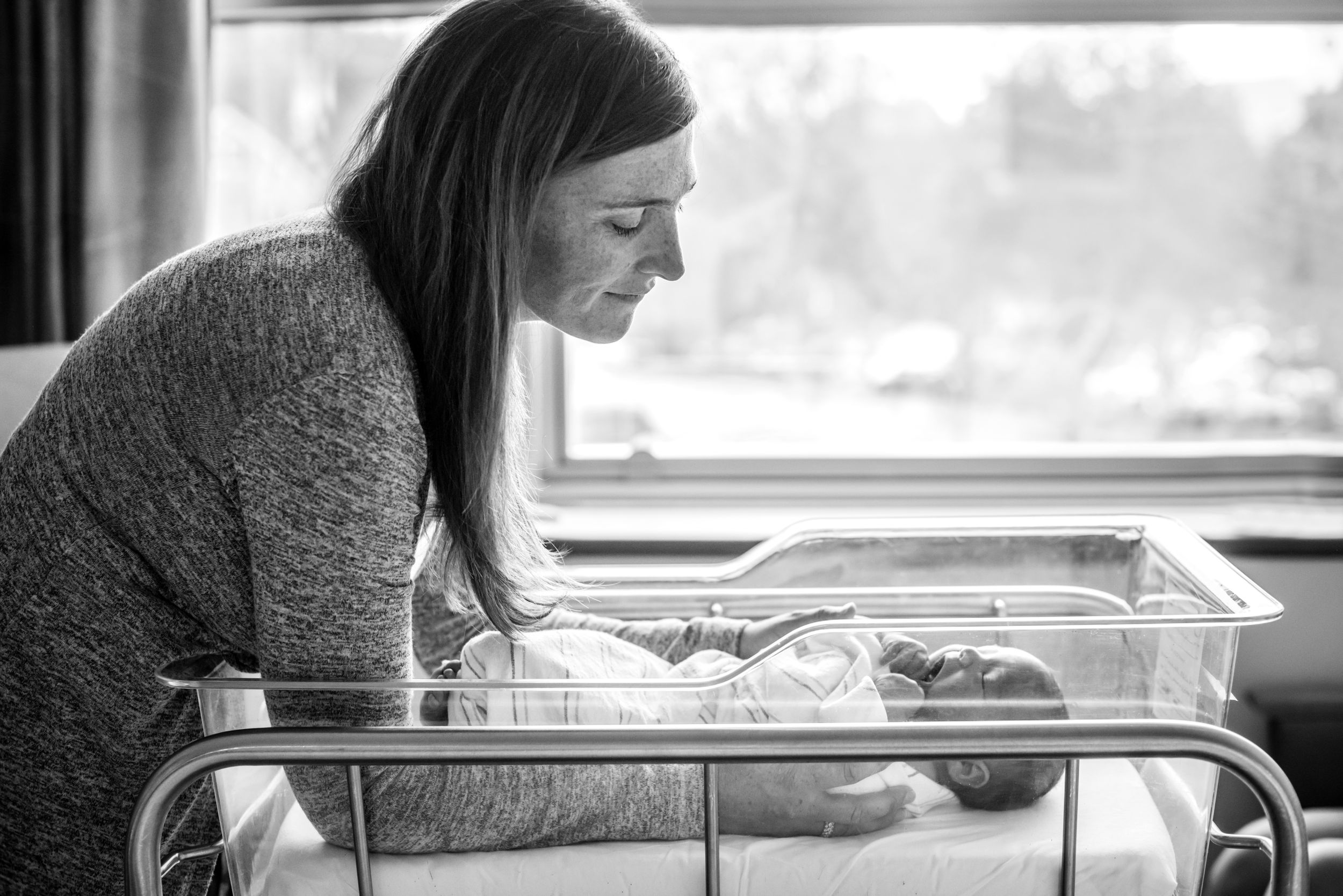 Mother gazing at newborn in hospital bassinet by heidi harting photography. Fresh 48 session, plymouth, ma