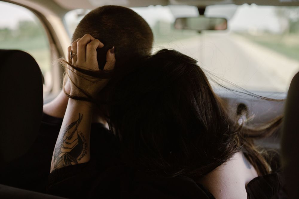 couple-roadtrip-driving-in-car-snuggling-winterset-iowa-raelyn-ramey-photography