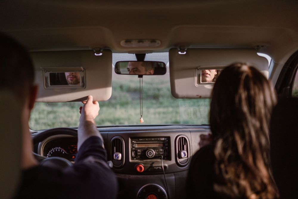 couple-sitting-in-car-looking-in-mirrors-winterset-iowa-raelyn-ramey-photography
