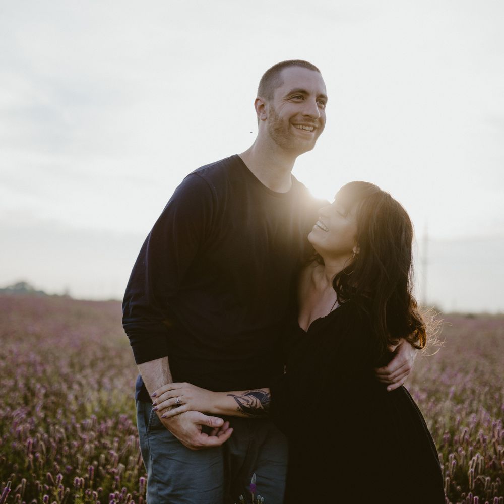 couple-standing-laughing-in-flower-field-winterset-iowa-raelyn-ramey-photography