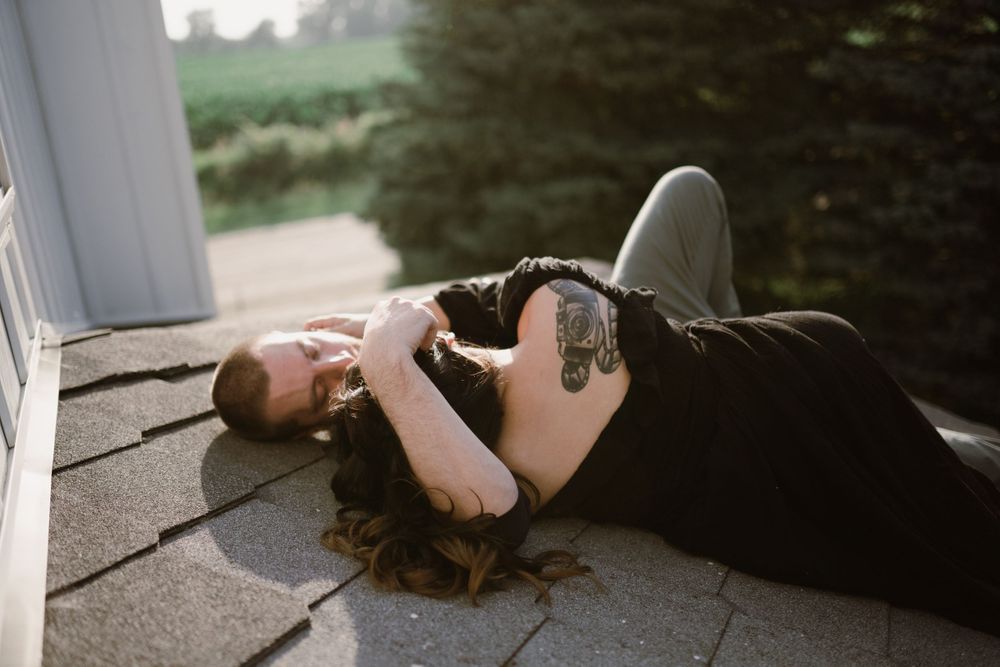 couple-laying-on-house-roof-cuddling-winterset-iowa-raelyn-ramey-photography