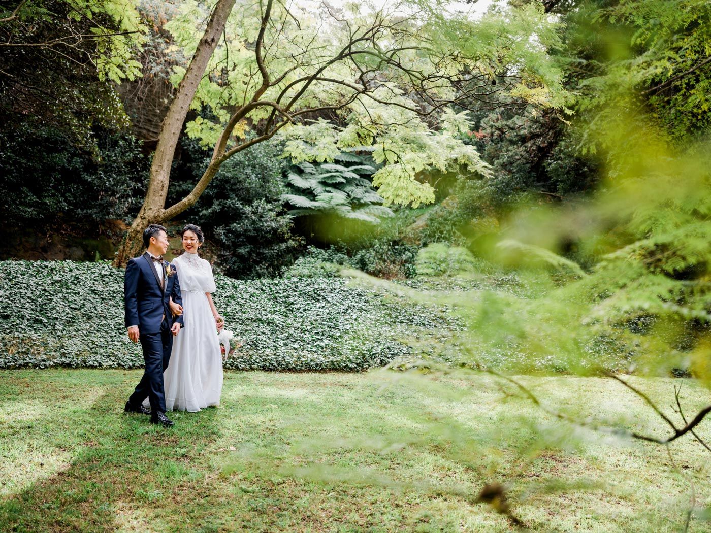 Elopement Bride and Groom walk hand in hand in a park