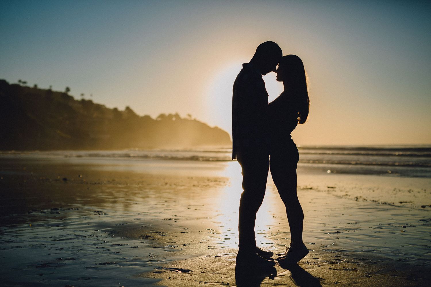 silhouette engagement photo at beach during sunset