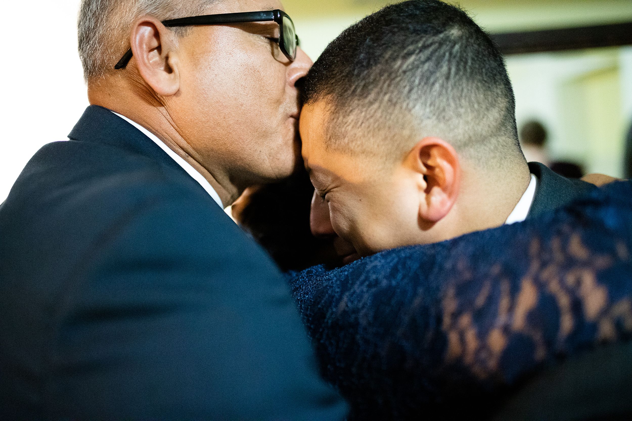 Groom cries as he is being hugged by his family by Hudson Valley photographer
