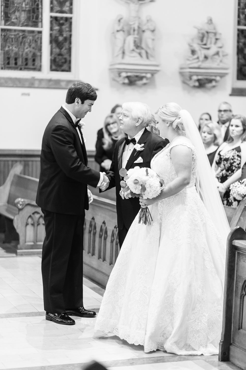 father of the bride gives bride away during mass at sacred heart in downtown savannah, ga
