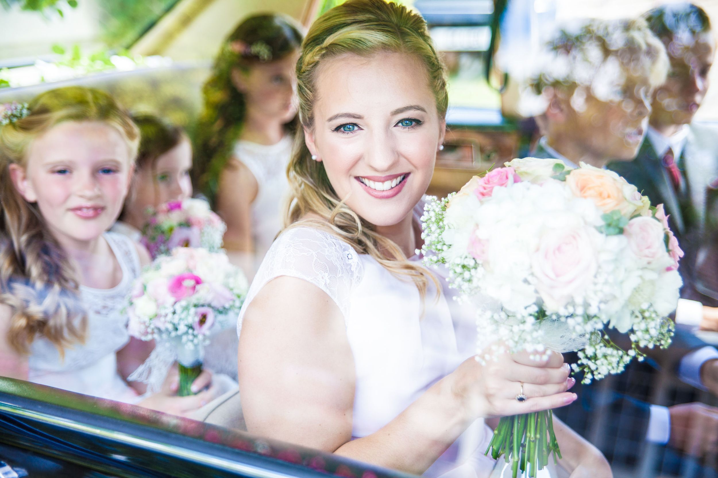 Bridesmaid in car holding bouquet