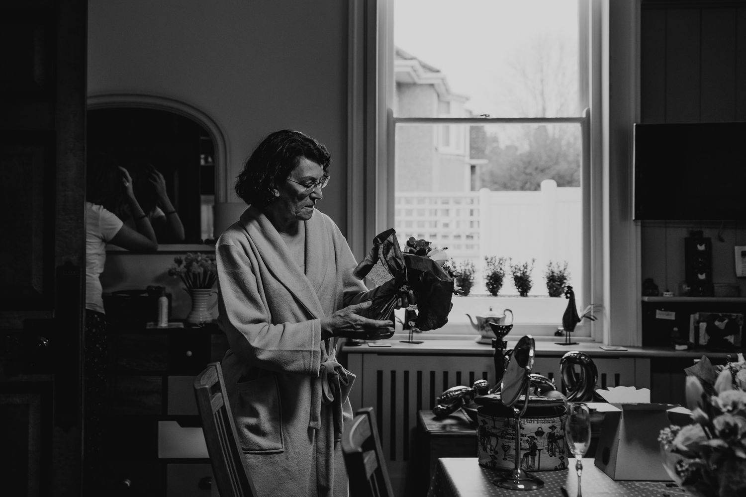 Black and white photo of mother of the bride preparing the wedding bouquet