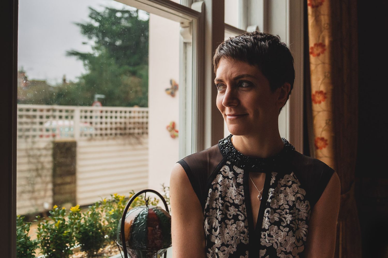 Bride looking out the window of her Salisbury home on the morning of her wedding.