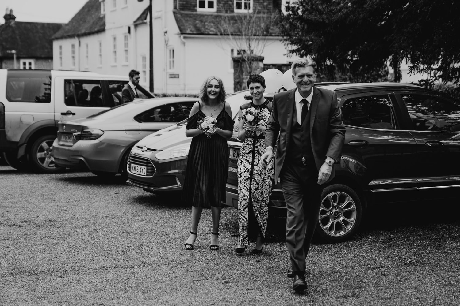 Black and white photo of the bride, her father and bridesmaid arriving at Salisbury Registry Office.