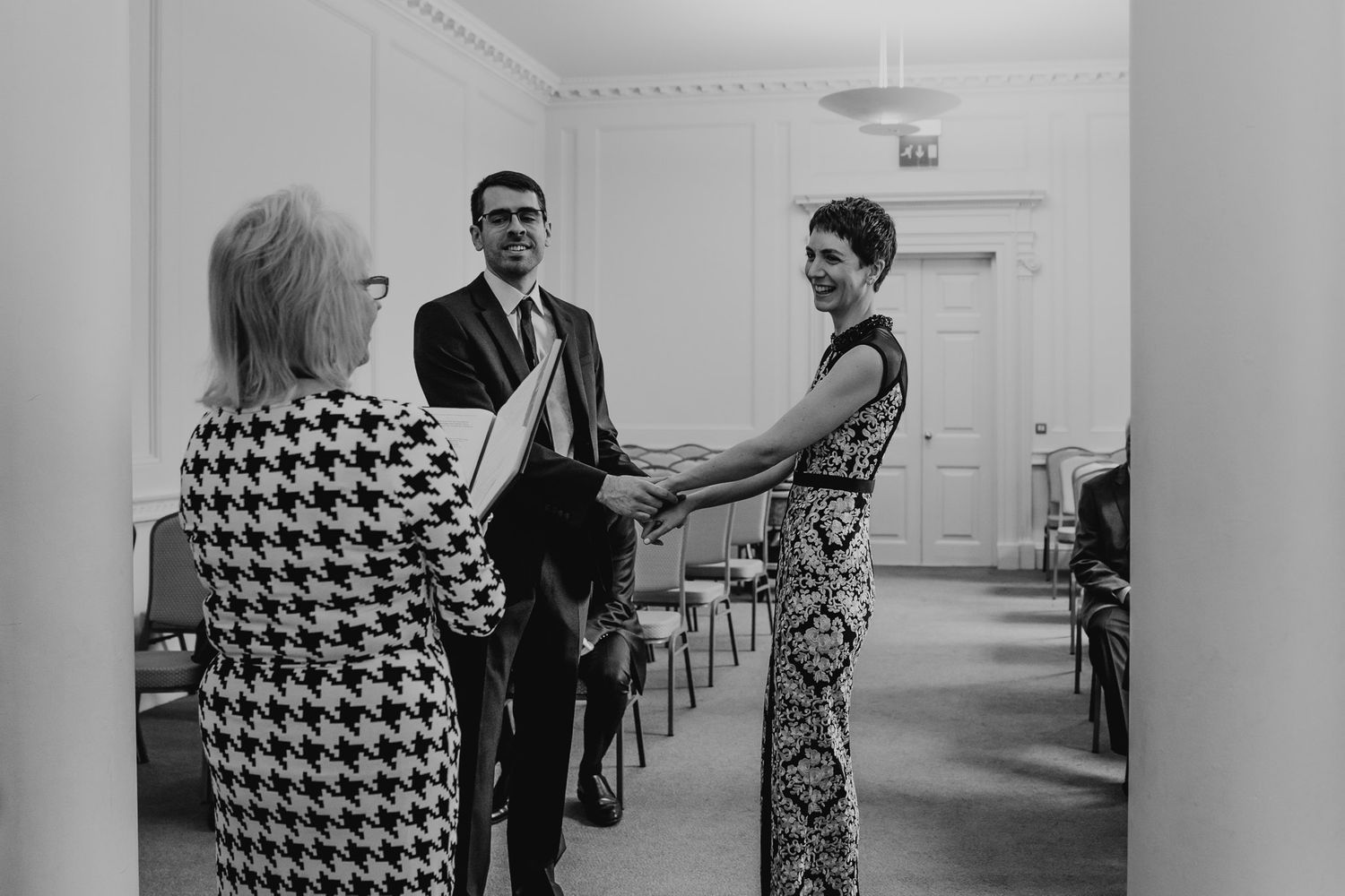 Black and white photo of bride and groom stood in front of registrar at Salisbury Registry Office.